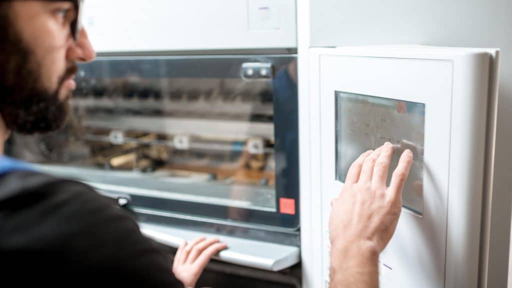 Worker operating flexographic printing equipment in operation.