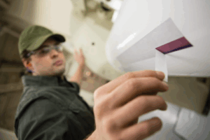 A close-up of a professional using flexo mounting tape used for printing applications.