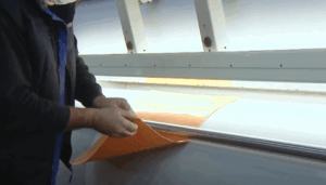 Operator using flexographic support equipment in a printing room.