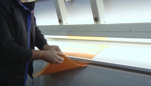 Operator using flexographic support equipment in a printing room.