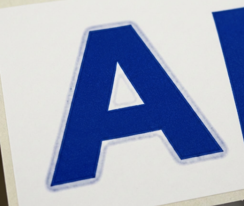 One of the most common flexo print defects, called haloing, shows up around a large blue letter A.