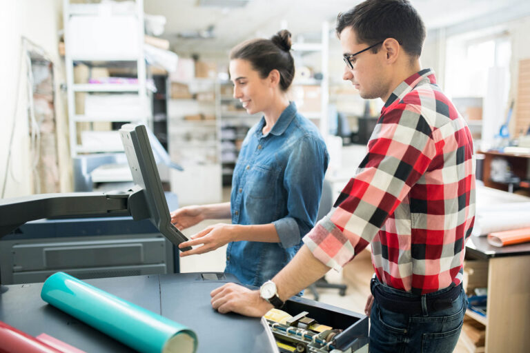 man and woman working with printing machine flexo